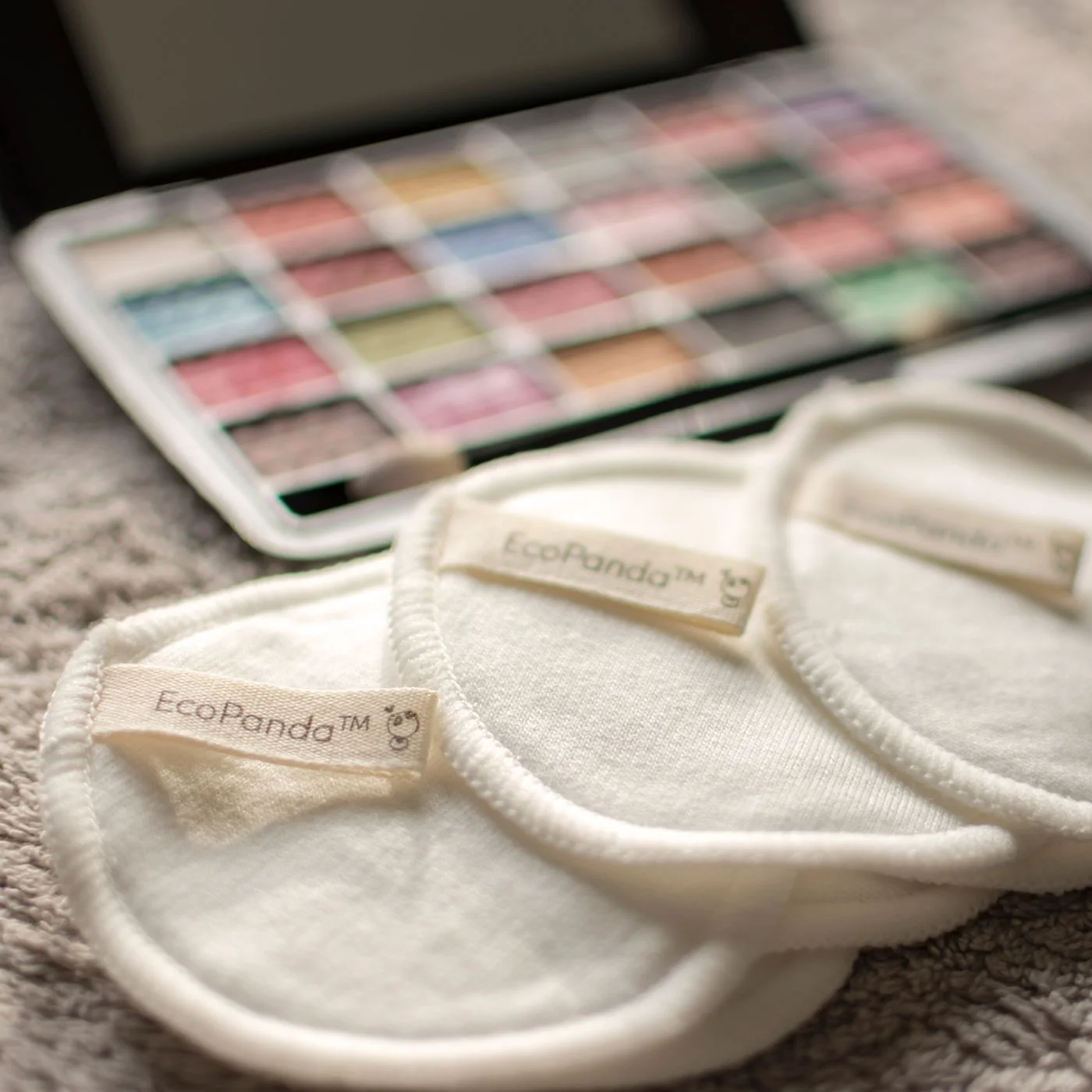 Reusable cotton pads beside a makeup palette.