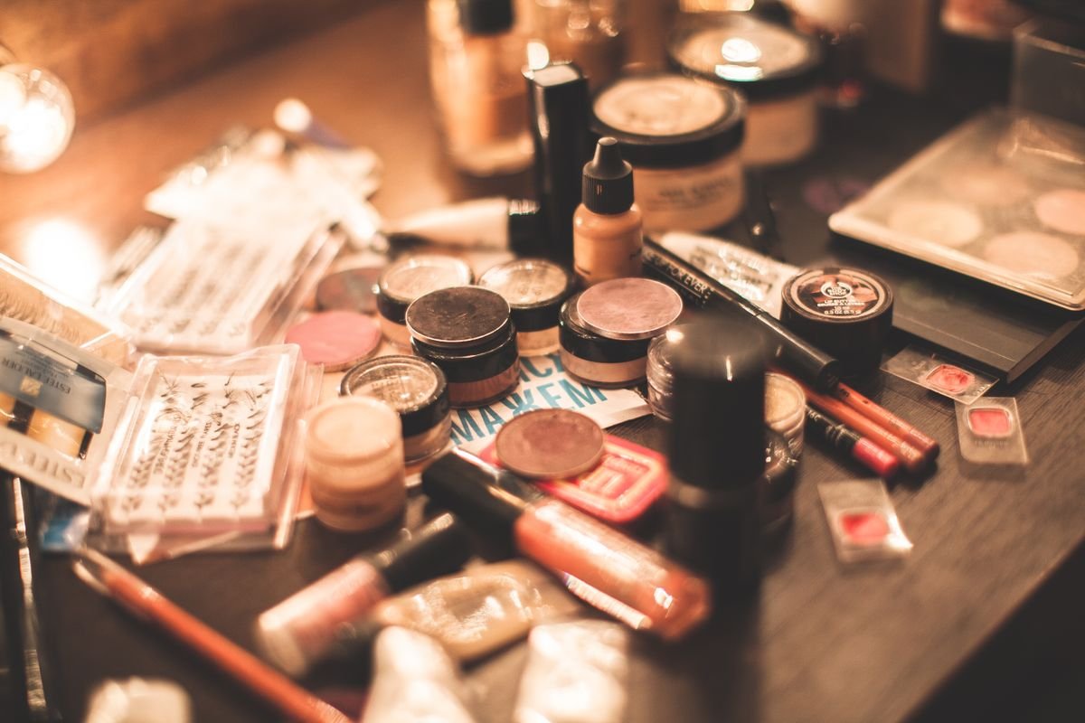 Cosmetic products and palettes arranged on a dressing surface.