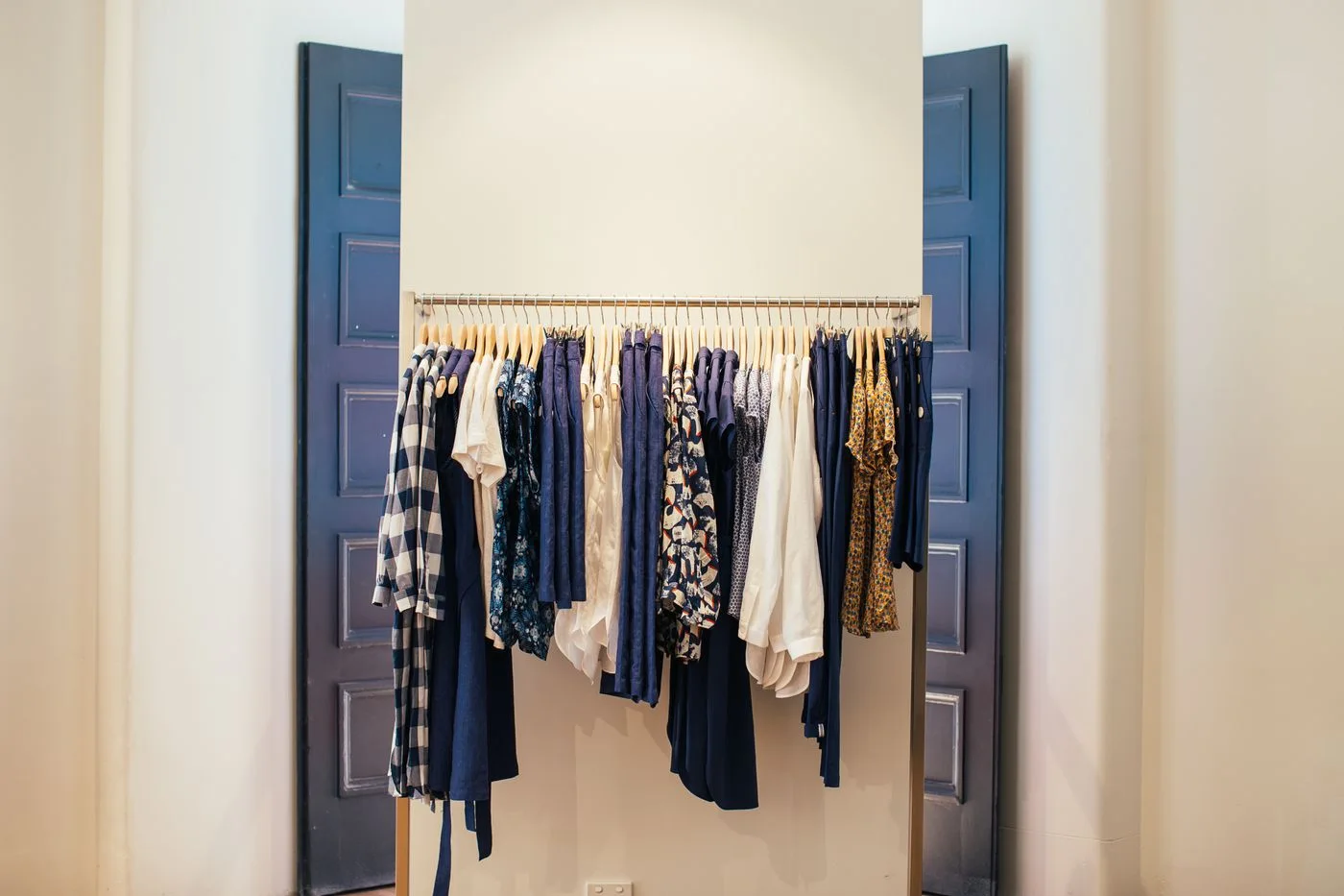 Garments hanging on a rail within a recessed storage area.