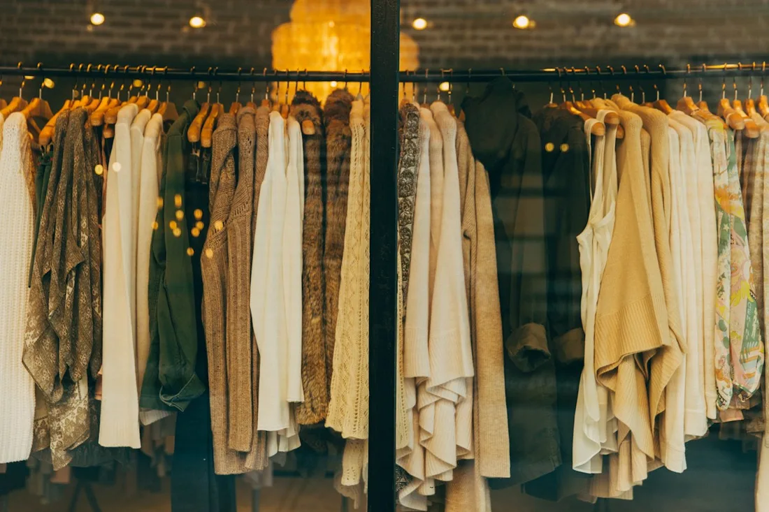 Garments hanging in a warmly lit clothing shop.