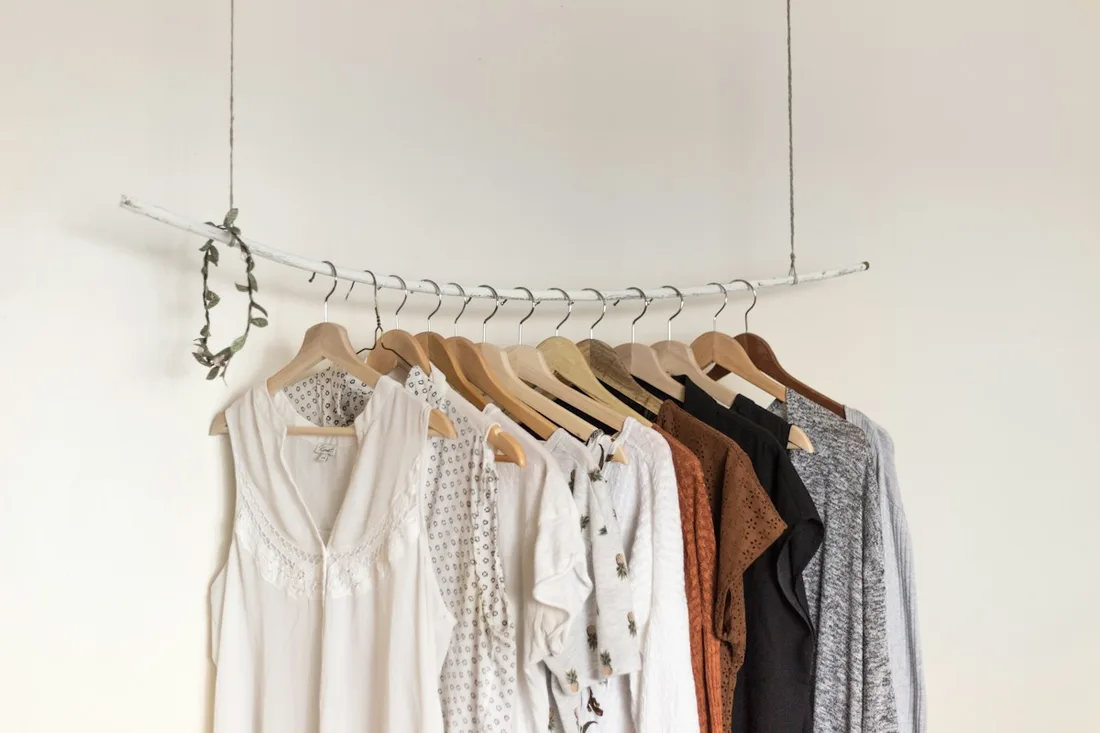 Pale shirts and other garments arranged on a clothes rail.